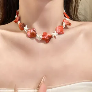Dettaglio della collana di perline in conchiglia rossa e stelle marine bianche