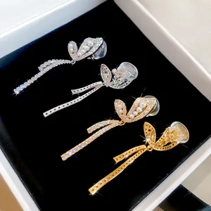 Close-up detail of 18k gold plated butterfly ear clips with sparkling zircons and pearls