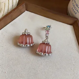 Detailed view of asymmetrical resin pudding earrings with colorful zircon accents