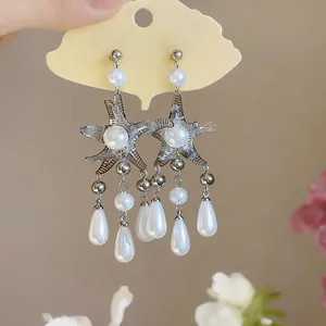 Vue détaillée de boucles d'oreilles étoile de mer argentées avec pampilles perles