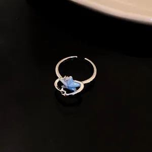 Dettaglio macro di un anello aperto in argento con pendente a stella marina blu e zircone