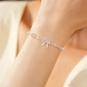 Dettaglio di elegante bracciale a fiocco argento con cuori in zircone rosa