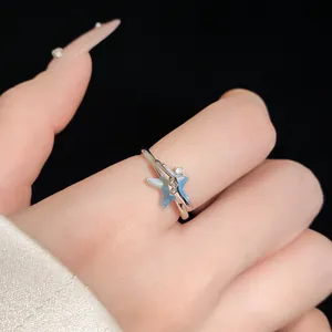 Primo piano di un anello a stella marina in argento con intarsio blu e zircone