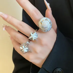 Gros plan sur des bagues de style bohème avec coquillages, étoiles de mer et perles élégantes
