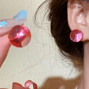 Close-up of pink translucent ball stud earrings with dopamine style