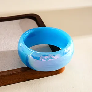 Close-up view of the vibrant blue marbled resin texture on a chunky aurora bangle bracelet