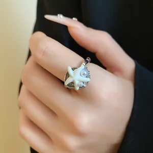 Vue détaillée d'une bague étoile de mer bohème avec perles et cristaux portée à la main