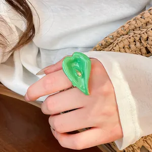 Vista dettagliata di un elegante anello aperto a calla in smalto verde sulla mano