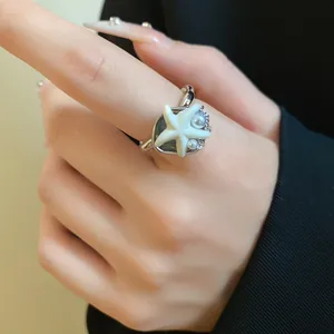 Vue rapprochée d'une bague ouverte étoile de mer bohème avec des perles délicates sur un doigt