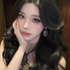 Close-up of vintage palace style earrings with blue teardrop crystals on an Asian model.