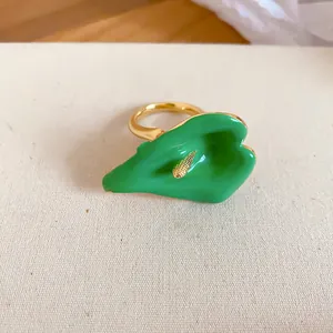 Dettaglio macro di un elegante anello a forma di calla in smalto verde con pistillo d'oro