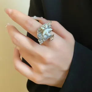 Gros plan d'une bague bohème en métal en forme de coquillage avec étoile de mer et perle.