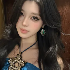 Retro court style green drop earrings with pearl and feather details on model
