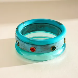 Detail of 3-piece marbled resin bangles with colorful sparkling rhinestone accents