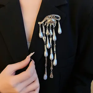 Elegant vintage silver eye brooch with cascading pearl waterdrop tassels on a black blazer