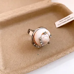 Bague ouverte élégante en coquillage avec strass brillants et perles sur un plateau