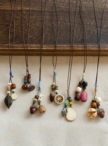 Handmade Mori-style botanical necklaces with acorns and wooden beads on woven cord decoration