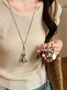 Detail view of forest-style handmade necklaces with acorns and wooden beads.