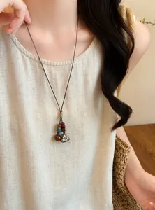 Handmade forest style acorn pendant necklace on a long brown cord worn with linen top