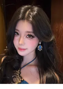 Elegant model wearing vintage court-style teardrop feather earrings with pearls