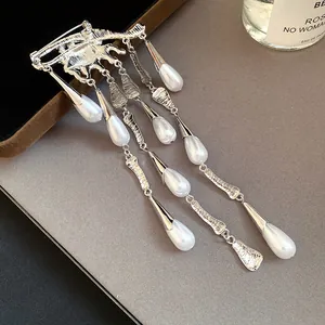 Detailed view of the silver-toned eye-shaped brooch with elegant teardrop pearl tassels.