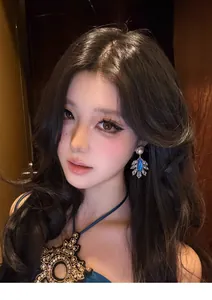 Vintage court style drop earrings with blue stones and pearls shown on an Asian model face