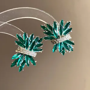 Vista macro detallada de elegantes pendientes de botón de diamantes de imitación verdes