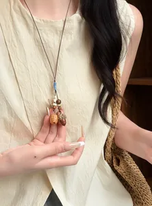 Detail view of a handmade acorn necklace with woven cord for forest style women.