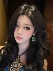 Elegant close-up of green teardrop feather earrings with pearl detail on a model