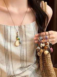 Handmade Mori-style acorn necklace detail with natural beads and woven rope