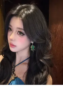Close-up of vintage palace style green teardrop earrings with pearls on a model