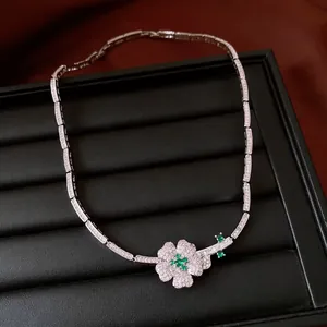 Close-up of a luxury zircon flower necklace featuring emerald green and white stones.