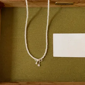 Close-up view of a refined pearl necklace featuring an elegant bow-shaped zircon pendant