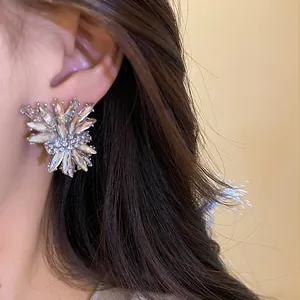 Detalle de cerca de los pendientes de botón de plata con pedrería inspirados en fuegos artificiales