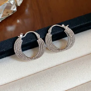 Detail view of 18k gold plated textured multi-strand hoop earrings in silver finish