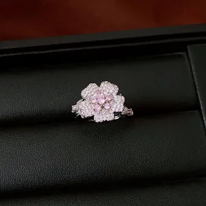 Close-up detail of a luxury flower ring with pink zircons on black leather box