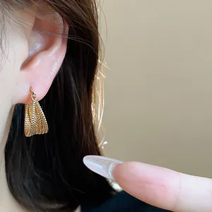Detailed view of elegant 18k gold plated multi-layered hoop earrings worn on ear