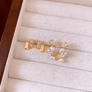 Detailed view of elegant French style earrings with zircon and pearls in a jewelry tray.