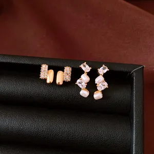 Close-up of elegant gold zircon and pearl drop earrings on black display tray