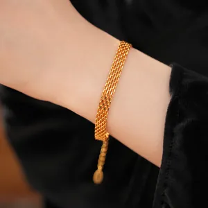 Close-up of 18k gold plated multi-strand chain bracelet on wrist showing texture