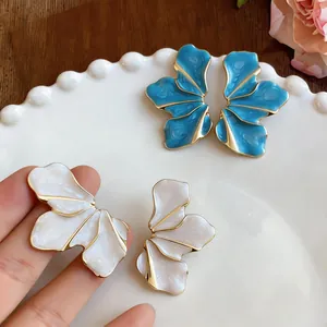 Detailed view of elegant blue and white enamel flower petal stud earrings.