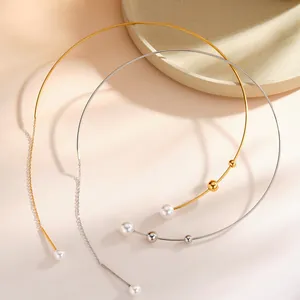 Dettaglio di collane torque in acciaio inossidabile oro e argento con perle e sfere