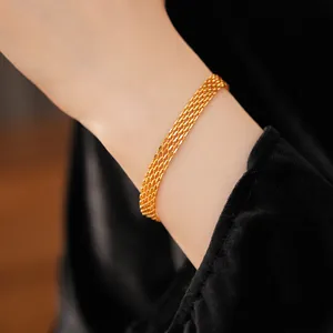 Close-up detail of a layered 18k gold plated mesh chain bracelet on a woman's wrist