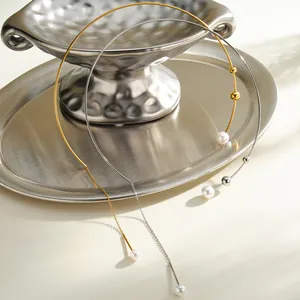 Dettaglio di eleganti girocolli in acciaio inox con perle su vassoio di metallo argentato