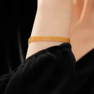 Detailed close-up of a minimalist 18k gold plated mesh chain bracelet on a woman's wrist