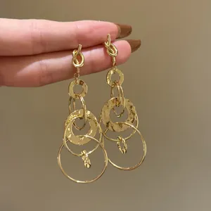 Elegant minimalist gold dangling earrings with knotted top and multiple circular rings