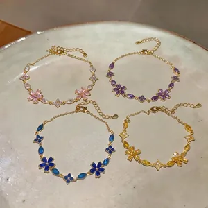 Elegant French-style zircon flower bracelets in four vibrant colors displayed on ceramic tray