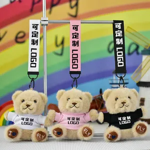 Detail showing three teddy bear plush keychains in white, pink, and black outfits.