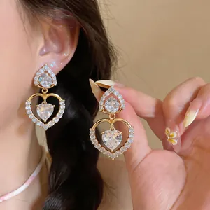 Detailed macro view of gold plated heart earrings with sparkling zirconia stones