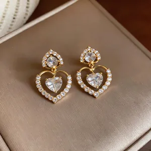 Close-up of elegant 18k gold plated heart-shaped earrings with clear zircons